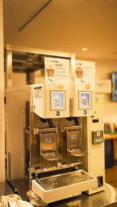 a kitchen with a coffee machine on a counter at Hotel Sanrriott Osaka Hommachi in Osaka