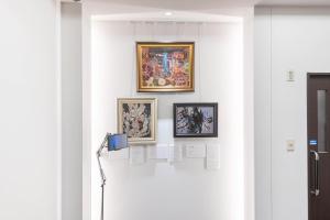 a wall with three framed pictures on a wall at Hotel Sanrriott Osaka Hommachi in Osaka