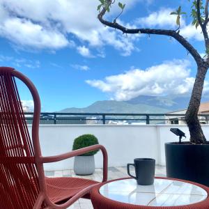 a red chair and a coffee table on a balcony at Shanlin INN in Hualien City