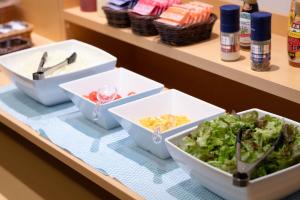 a table with three bowls of food on a counter at Hotel Sanrriott Osaka Hommachi in Osaka