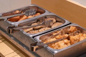 two trays of donuts and other food on a counter at Hotel Sanrriott Osaka Hommachi in Osaka