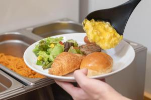 a person is holding a plate of food at Hotel Sanrriott Osaka Hommachi in Osaka