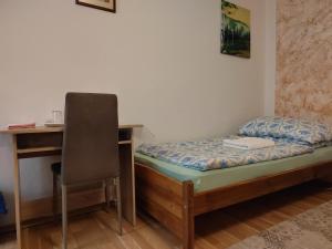 a bedroom with a bed and a desk and a chair at Mária in Košice