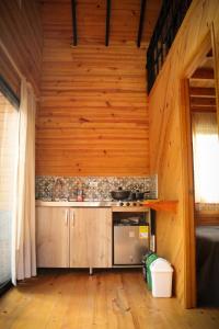 a kitchen in a log cabin with a stove at Vital Ecohotel Cabañas in Guarne