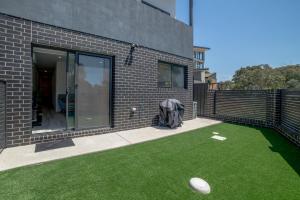 um edifício com um quintal com um frisbee na relva em Chic 2-Bed Home with Backyard, BBQ & Parking em Phillip