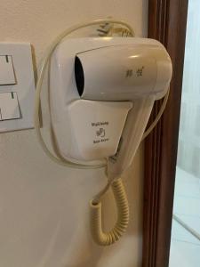 a hair dryer is hanging on a wall at Heuang Paseuth Hotel 香帕赛酒店 in Luang Prabang