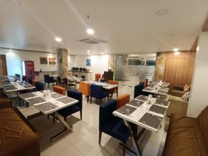 a dining room with tables and chairs and a unintention at IRIS HOTEL BY HOP in Tirupati