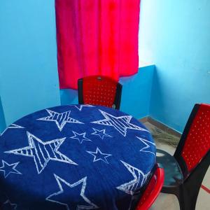 a blue table with stars on it with two red chairs at Piyari Home stay 2 in Kolkata
