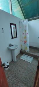 een badkamer met een wastafel en een douchegordijn bij Ecoturístico La Tarde in Puerto Jiménez