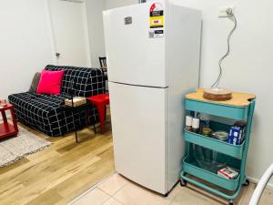 een witte koelkast in een woonkamer met een bank bij Penrith Beautiful Granny sleep 4 in Penrith