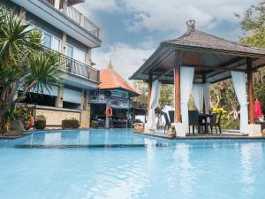 a swimming pool with a gazebo next to a building at Bayside Bungalows in Candidasa