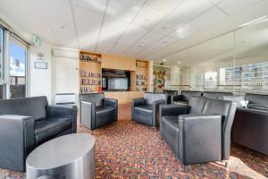 a waiting room with black leather chairs and a table at Center 1-Bed with Sauna, Gym, BBQ & Parking in Canberra