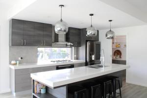 a kitchen with white countertops and black cabinets at Bottlebrush Moama in Moama