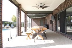 a patio with a table and a ceiling fan at Bottlebrush Moama in Moama