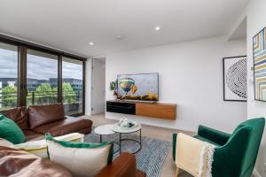 a living room with a couch and a tv at Spacious 2-Bed, Stunning Views in Central Canberra in Kingston 