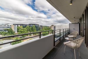 a balcony with two chairs and a view of the city at Spacious 2-Bed, Stunning Views in Central Canberra in Kingston 