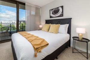 um quarto com uma cama grande e uma varanda em Spacious 2-Bed, Stunning Views in Central Canberra em Kingston 