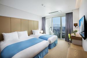 Postel nebo postele na pokoji v ubytování Hotel Whistlelark Jeju
