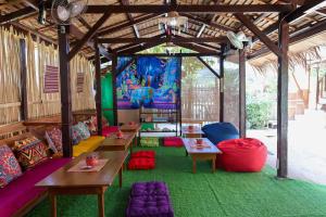 a room with tables and chairs and a mural at Garpeza Backpackers in Port Barton