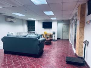 a living room with a couch and chairs in a room at Los Guacamayos La Ceiba in La Ceiba