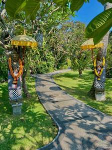 a path in a park with two statues of umbrellas at Bayside Bungalows in Candidasa