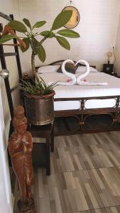 - une chambre avec un lit et une plante dans l'établissement Baan sikhao Yanui, à Rawai Beach