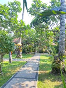 a walkway in a park with trees and a pathway at Bayside Bungalows in Candidasa