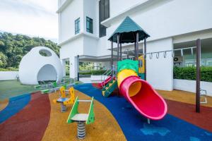 une aire de jeux avec différents types de toboggans devant un bâtiment dans l'établissement The Mark Cheras by Feel Home, à Kuala Lumpur