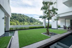 une cour avec un arbre au milieu d'un bâtiment dans l'établissement The Mark Cheras by Feel Home, à Kuala Lumpur