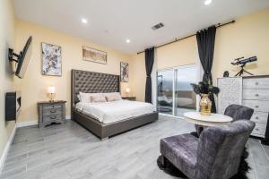 a bedroom with a bed and a table and a chair at Luxurious Estate w/ Heated Pool and Amazing Views in San Bernardino +37 photos