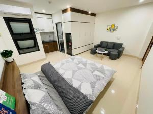 a living room with a bed and a couch at FlowerGod Apartments - BlackPink HomeStay in Hanoi
