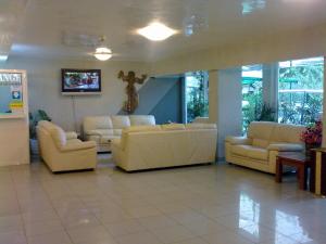 a living room with white couches and a tv at Hotel Yantra in Sunny Beach