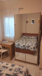 een slaapkamer met een bed, een bureau en een spiegel bij Panorama Sea Esta 1 bedroom with sea view in Perea