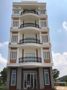 d'un grand bâtiment blanc avec balcon. dans l'établissement Hà Hùng Panorama Hotel (Cơ sở 2 - Cho thuê nhà nguyên căn cách chợ đêm 300m), à Hà Tiên