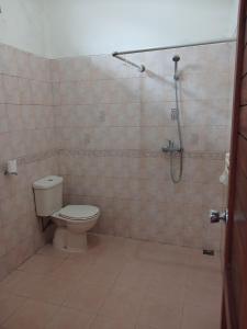 a bathroom with a toilet and a shower at Hotel MBC Ruteng in Ruteng
