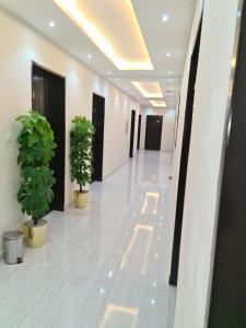 a hallway with two potted plants in a building at فخامة اليمامة للشقق الفندقية in Riyadh