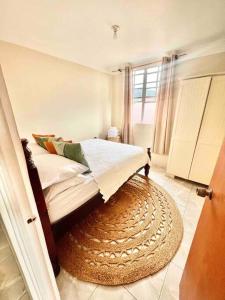 a bedroom with a bed with a rug and a window at Tropical Penthouse Overlooking Caribbean Sea in Mahaut