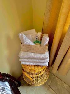 a stack of towels in a basket next to a window at Tropical Penthouse Overlooking Caribbean Sea in Mahaut
