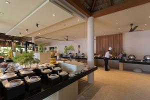 a man standing in front of a buffet in a restaurant at Veligandu Maldives Resort Island in Rasdhoo