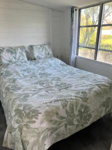 ein Bett in einem Schlafzimmer mit einer Bettdecke darauf in der Unterkunft BUNGALOW 60 M2 in Roquebrune-sur-Argens