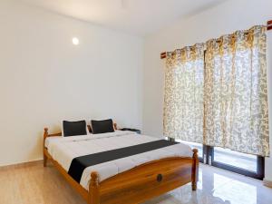 een slaapkamer met een bed en een raam met gordijnen bij Collection O Continental Bay Inn in Chennai