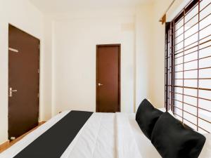 een slaapkamer met een bed met zwarte stoelen bij Collection O Continental Bay Inn in Chennai
