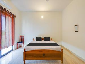 een slaapkamer met een bed en een stoel bij Collection O Continental Bay Inn in Chennai