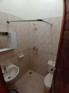 Baño pequeño con aseo y lavamanos en Hotel MBC Ruteng, en Ruteng