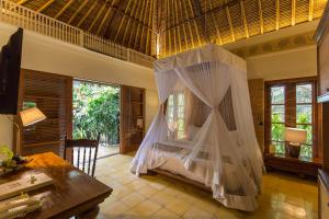 Habitación con cama con mosquiteras. en Plataran Ubud Hotel & Spa - CHSE Certified, en Ubud