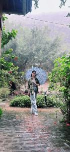 a person standing in the rain with an umbrella at Ham Rong Bungalow in Xuân Sơn