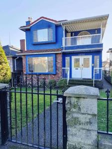 a blue house with a black fence at LLT HomeAway in Vancouver
