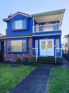 a blue house with a porch and a balcony at LLT HomeAway in Vancouver