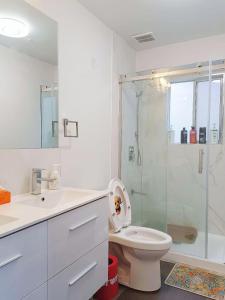 een witte badkamer met een toilet en een douche bij LLT HomeAway in Vancouver