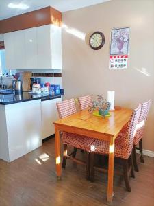 a kitchen with a wooden table with chairs and a clock at LLT HomeAway in Vancouver